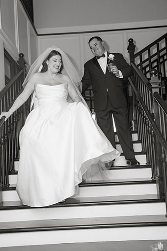 black and white image of newlyweds desending staircase at Kimpton Hotel Fontenot